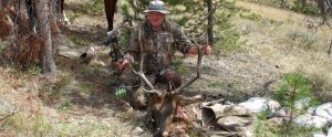 A hunter holding a dead elk by it's antlers in Colorado